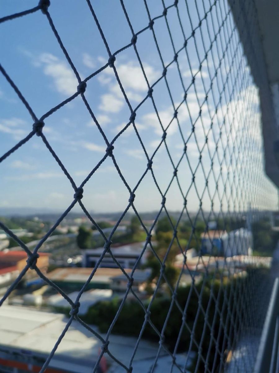 Detalle de malla de seguridad con vista a la ciudad